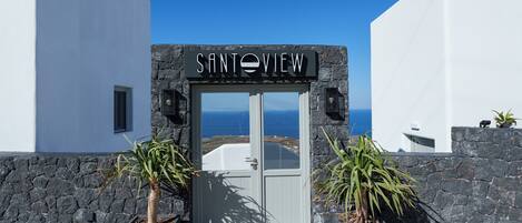 A building entrance with a sign reading "SANTOVIEW" and a view of the sea.
