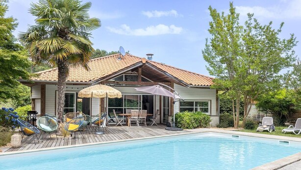 A two-story house with a swimming pool, outdoor furniture, and a palm tree. - Villa Cormoran (MOLIETS ET MAA)