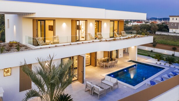 A modern two-story house with a swimming pool, outdoor seating, and a well-lit patio area. - Villa Javori Zadarvillas (Bibinje)