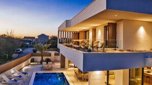 A modern two-story house with a swimming pool, outdoor seating, and a view of the surrounding area. - Villa Javori Zadarvillas (Bibinje)