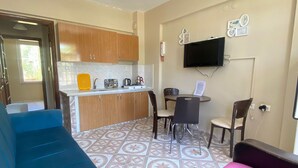 A compact living space with a kitchenette, a dining area, and seating arrangements.