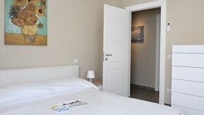 Ein Hotelzimmer mit einem Bett, einem Sonnenblumenbild, einer Tür und einer Wandklimaanlage.