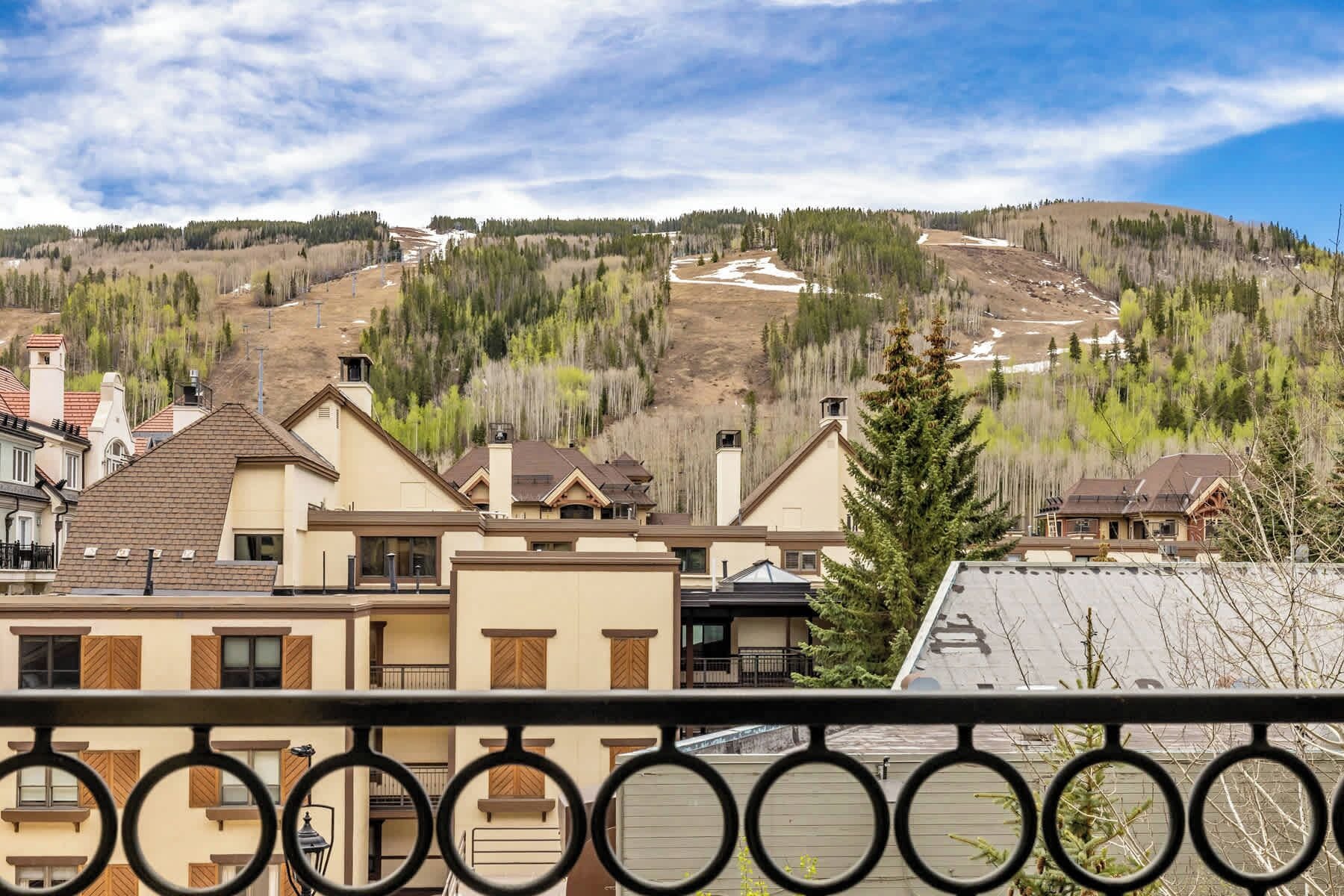 A residential area with houses, a clear sky, and a hilly landscape in the background.