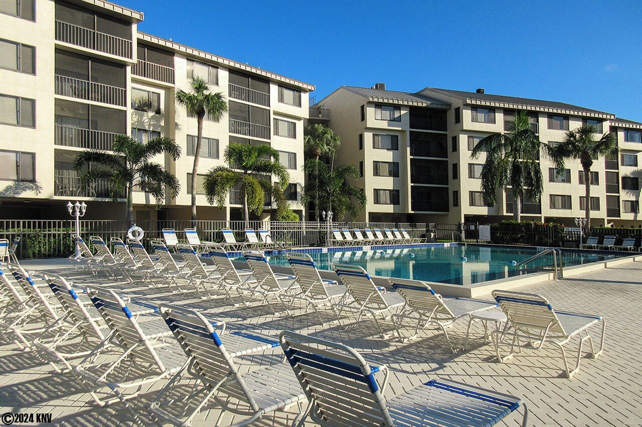 Ein Hotelpoolbereich mit Liegestühlen und einem klaren, blauen Pool.