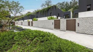 A modern building with a stone facade, a flat roof, and a small pool. - Villa Qabalah (Si Sunthon)
