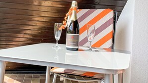 A table with a bottle of chardonnay and two glasses, set against a wooden backdrop.