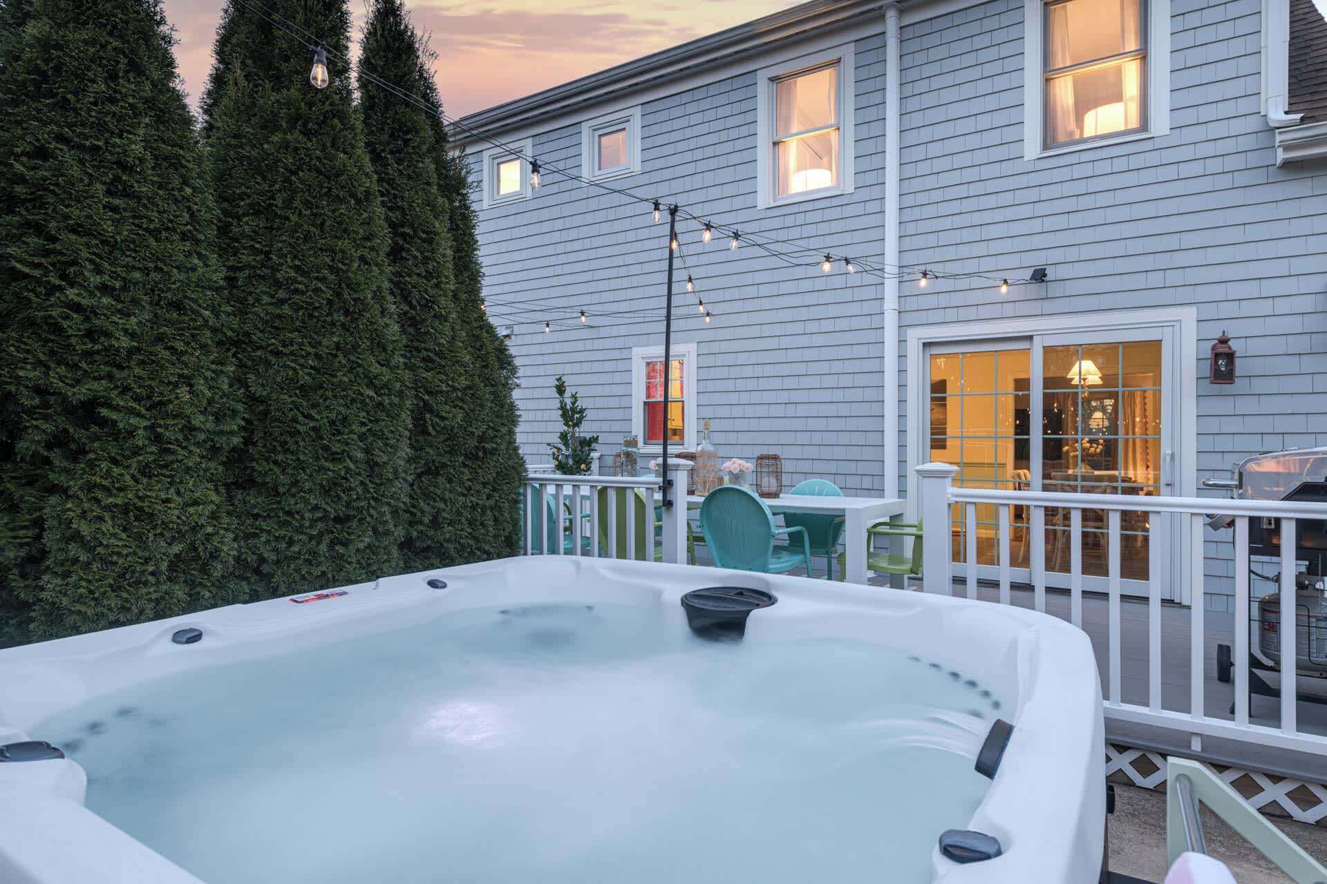 Een hottub op een terras met een huis op de achtergrond.