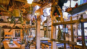 Un coin repas au style rustique, avec des meubles en bois, des plantes suspendues et divers objets décoratifs.