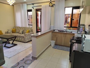 Deluxe-Apartment, Stadtblick | Wohnbereich | 24-Zoll-Smart-TV mit Digitalempfang