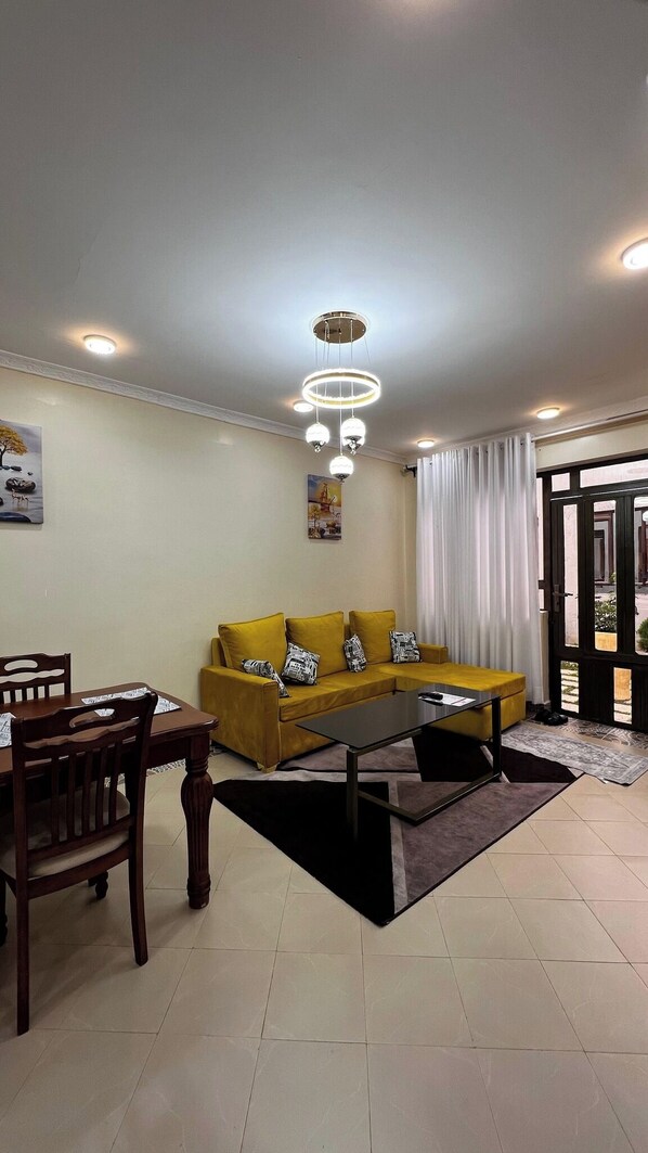 Familienapartment, Stadtblick | Wohnbereich | 24-Zoll-Smart-TV mit Digitalempfang