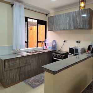 Familie appartement, uitzicht op de stad | Privékeuken | Een koelkast, een microgolfoven, kookgerei, borden en bestek