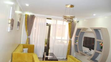 Familieleilighet, byutsikt | Oppholdsområde | En 24-tommers smart-TV med digitale kanaler