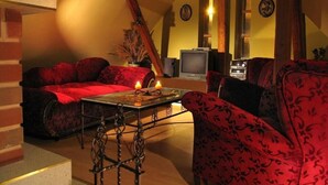 Un salón acogedor con un sofá rojo, una mesa de centro y una chimenea.