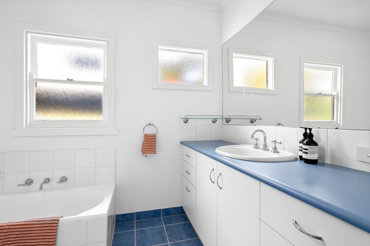 A modern bathroom with a bathtub, a sink, and a mirror.