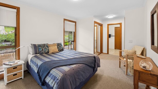A bedroom with a bed, bedside tables, a desk, and a mirror. - BeachHaven (Aireys Inlet)