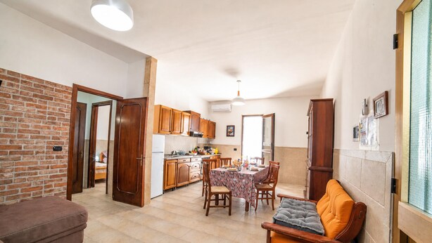 A compact living space with a kitchen, dining area, and a sofa. - Villa Benedetta 50m From Beach (Lecce)