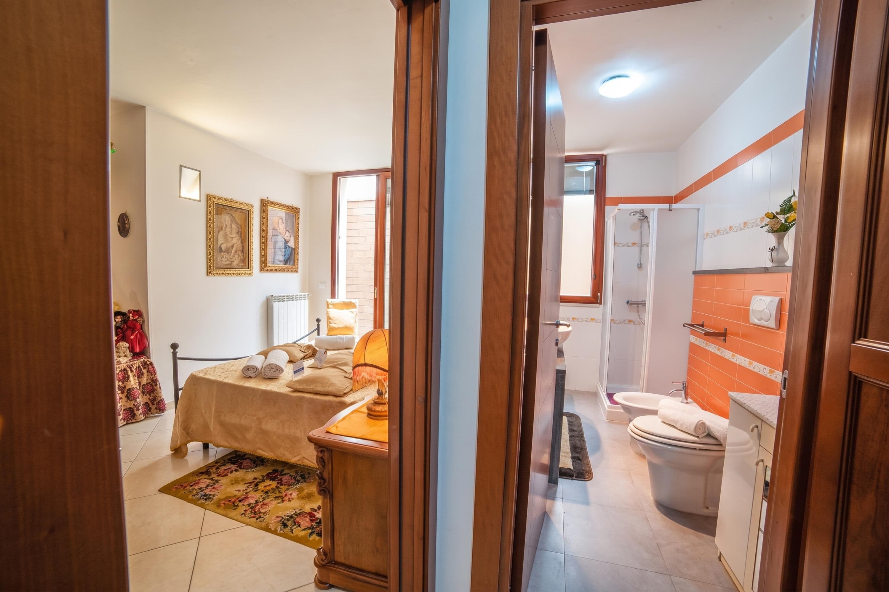 Una camera d'albergo con un letto, un tavolino, una sedia, una doccia e un bagno.
