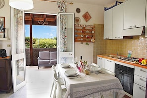 Una cocina con una mesa de comedor para dos personas, estufa y vistas al exterior.