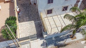 A multi-story building with a courtyard, outdoor seating, and a satellite dish.