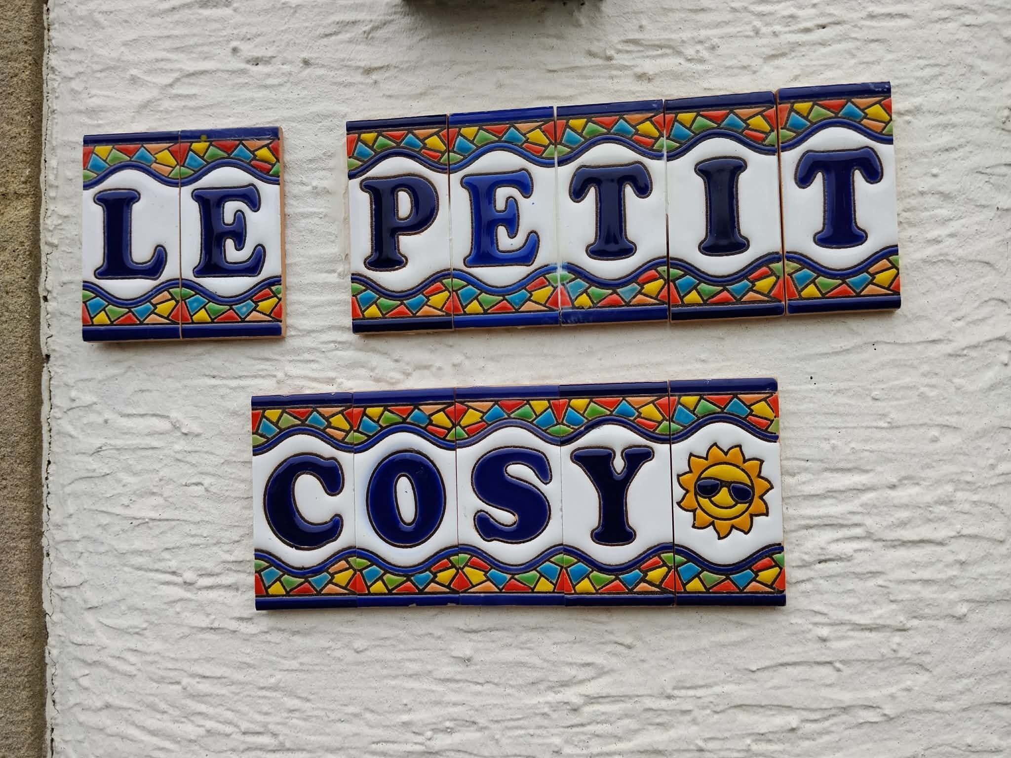 Three ceramic tiles with text and decorative borders on a wall.