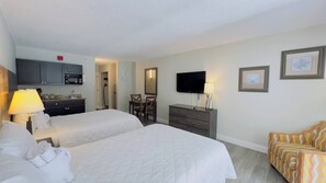 A hotel room with two beds, a TV, a desk, and a dining area. - LA41 Sunny studio on the beach + Pool (Myrtle Beach)