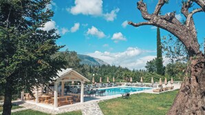 A pool area with lounge chairs and a gazebo. - Pelithea Aparthotel (Corfu)