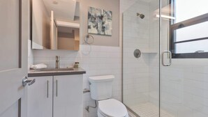 Une salle de bain moderne avec une douche à parois de verre, des toilettes et un lavabo avec une serviette.