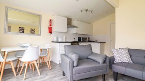 Un espacio habitable compacto con comedor, kitchenette y zona de estar.