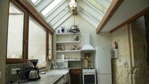 A kitchen with a skylight, a coffee maker, a microwave, a stove, and a refrigerator. - Leonardo at our 'Clos Lussault' near Amboise in the Loire Valley (Lussault-sur-Loire)