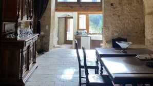 A rustic stone-walled room with a wooden dining table, chairs, and a chandelier. - Leonardo at our 'Clos Lussault' near Amboise in the Loire Valley (Lussault-sur-Loire)