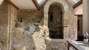 A stone-walled kitchen with a skylight, rustic wooden beams, and a built-in oven. - Leonardo at our 'Clos Lussault' near Amboise in the Loire Valley (Lussault-sur-Loire)