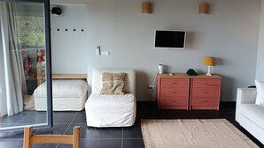 Ett modernt sovrum med en säng, ett skrivbord, en tv och en garderob.