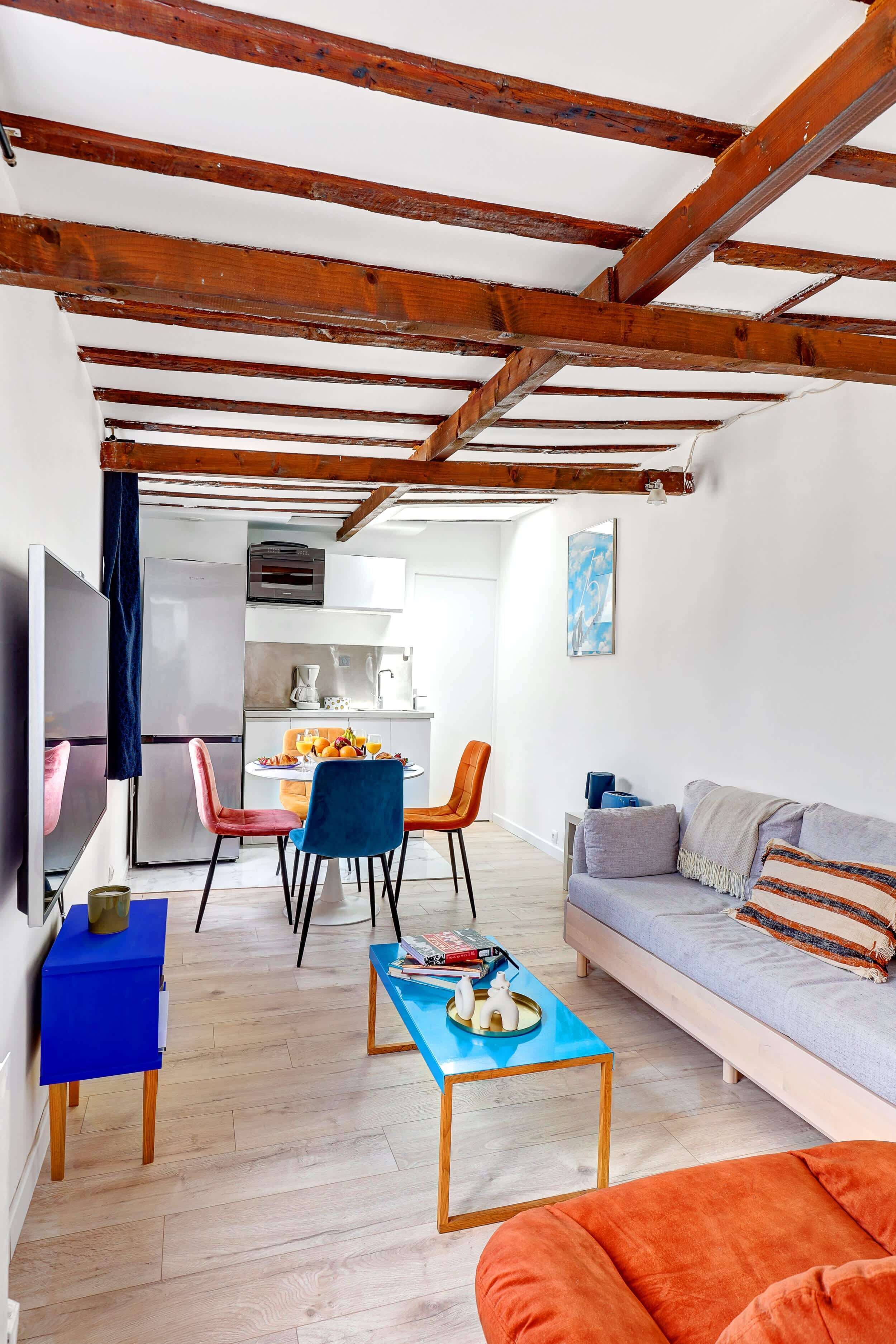 A modern living space with a kitchen, dining area, and seating.