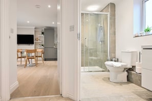 Une salle de bain moderne avec une douche à parois de verre, des toilettes et un lavabo.