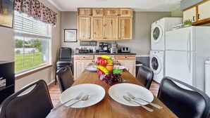 A dining area with a wooden table, chairs, and a view of a mountain through a window. - Pool, secluded but mins to strip NO stairs Fishing (Branson)
