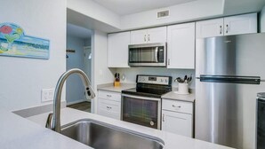 A modern kitchen with stainless steel appliances, a built-in oven, and a microwave. - Bayfront Kontiki 107 (Rockport)