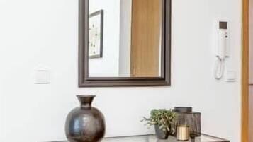 A modern console table with a mirror, a vase, and a small plant.