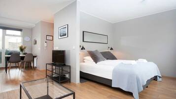 A modern bedroom with a bed, bedside tables, a desk, and a chair.