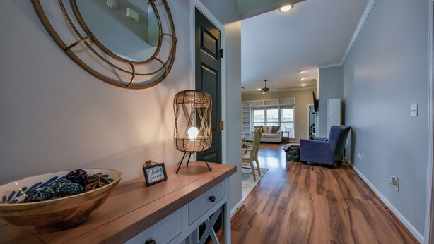 A modern living room with a wooden floor, a blue sofa, and a dining area with a wooden table and chairs.