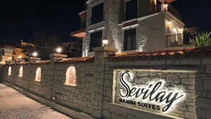 Un edificio de paredes de piedra con un letrero que indica Sevillay Hanim Suites.