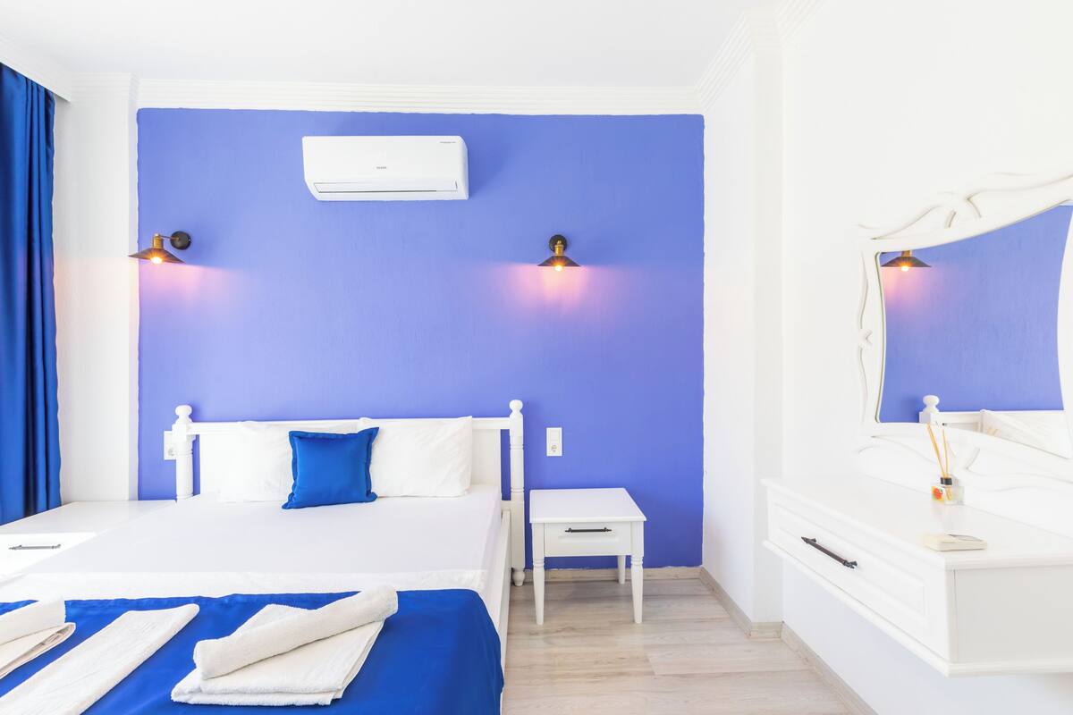 A bedroom with a bed, bedside table, and a nightstand.