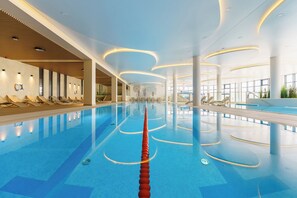 A modern indoor swimming pool with clear water, sun loungers along the sides, and a central lane divider. - Polanki Aqua Apartamenty - Family Vacations with a Pool & Wellness Facilities, FREE PARKING (Kolberg)