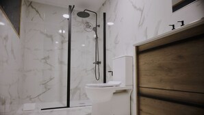 Een moderne badkamer met douche, toilet en een houten wastafelmeubel.