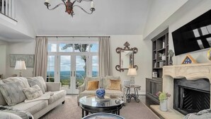 A spacious living room with a large window, a fireplace, and a cozy seating area.