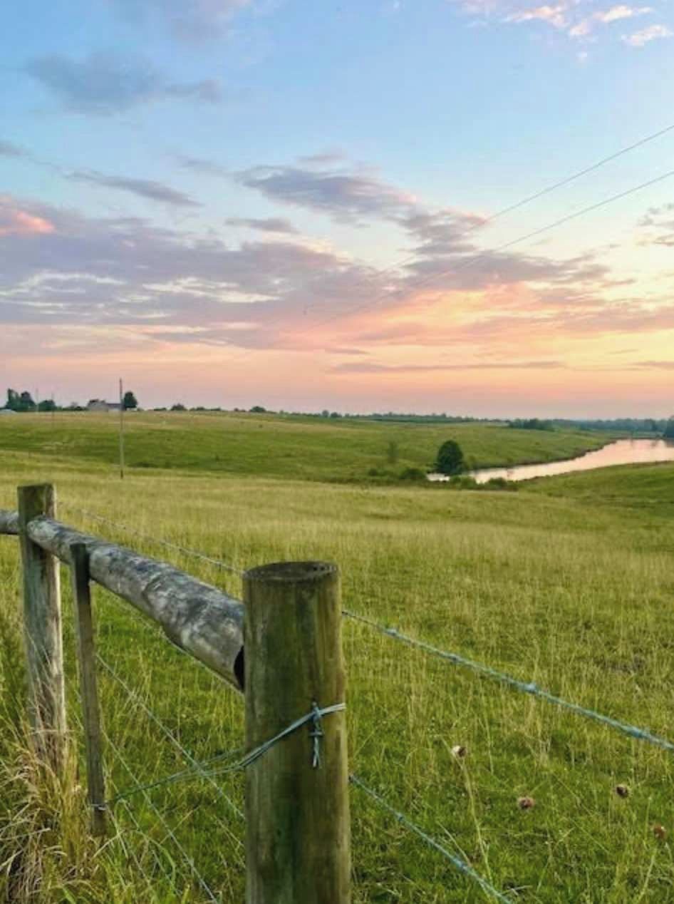Ländliche Landschaft mit Holzzaun und Feld.