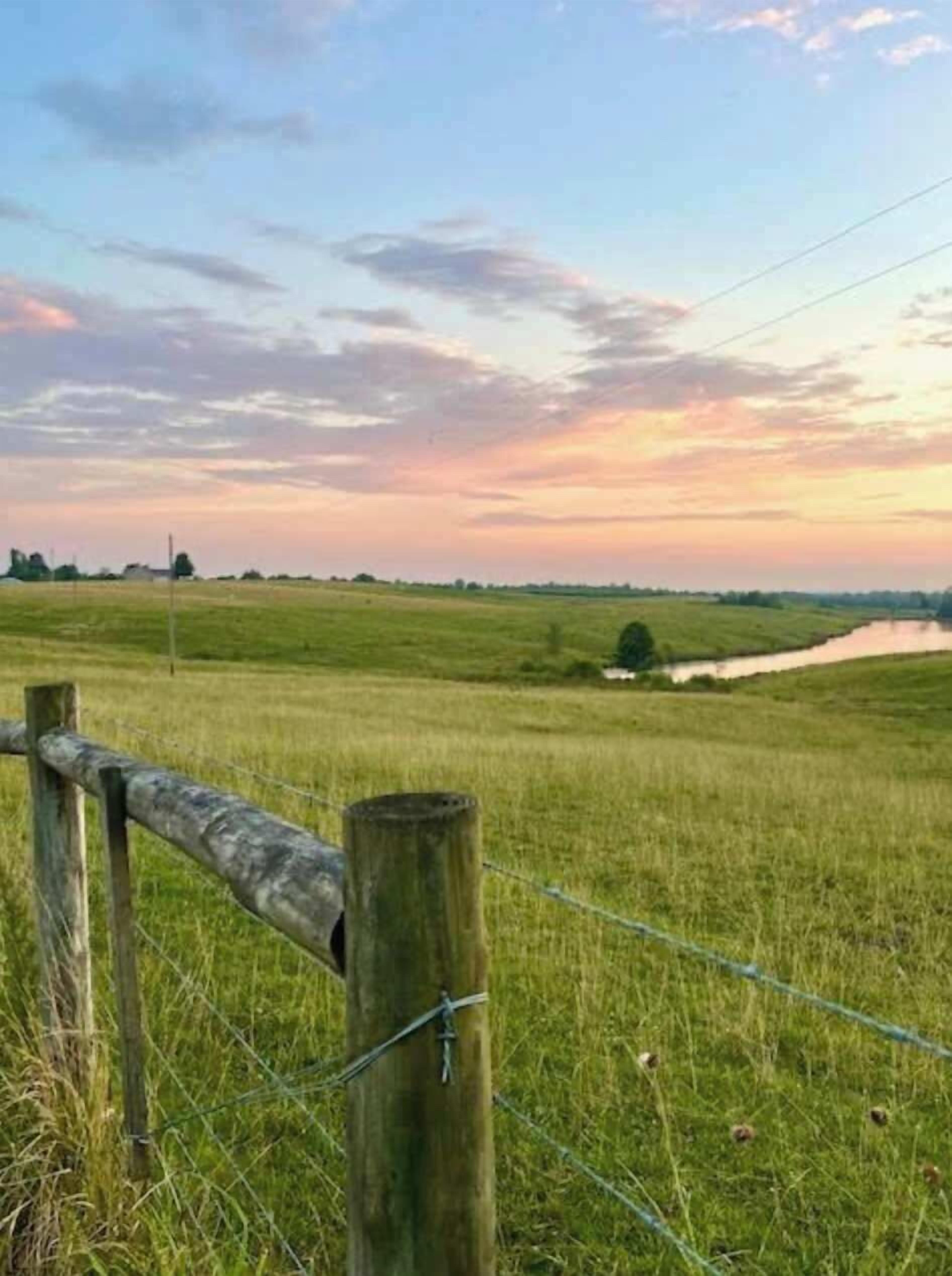 Ländliche Landschaft mit Holzzaun und Feld.