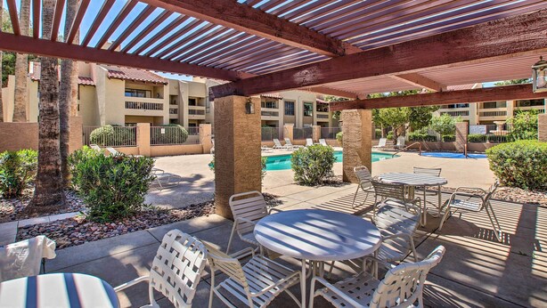 An outdoor patio area with tables and chairs, a pool, and a covered walkway. - Golfer's Haven: Scottsdale Gem Near 21 Courses (Scottsdale)