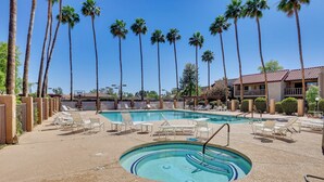 A pool area with multiple lounge chairs and a small hot tub. Tall palm trees surround the area. - Golfer's Haven: Scottsdale Gem Near 21 Courses (Scottsdale)