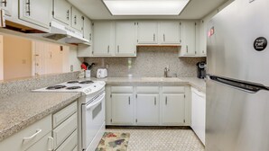 A kitchen with white cabinets, a stainless steel refrigerator, a granite countertop, and a hexagonal tile floor. - Golfer's Haven: Scottsdale Gem Near 21 Courses (Scottsdale)