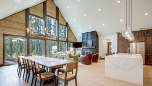 Een ruime keuken met een groot eiland, houten keukenkastjes en een open haard.